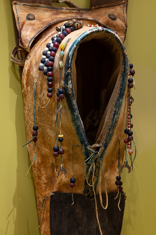 Comanche cradle board c. 1880 (photo 2 of 3) Wood slats, brass tack, seed beads, trade beads, silver crescent, brain-tanned hide, saddle leather, rawhide, blue, green, and yellow pigment, brass conchos.